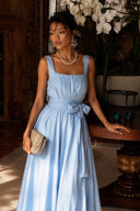 Full-length front view of the Azure Linen Sky-Blue/Beige A-Line Backless Pearl Wide-Leg Jumpsuit featuring a square neckline, adjustable waist bow, pearl back detail, flowing wide-leg fit and elegant resort styling.