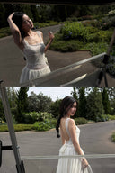 Woman in a Vogsion Amber Light Lace Spliced Open Back Tie Strap Maxi Dress standing in front of a car window with reflection.