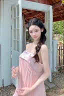 Woman in a Vogsion Odette Pearl-Trim Bubble Mini standing in front of a white door with a wooden roof.