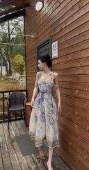 Vogsion Dawning Floral Corset Midi Dress featuring a blue and white boho floral pattern and tie straps, shown on a customer in a scenic vacation setting