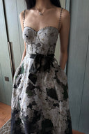 Vogsion Seraphina Floral Bustier Dress from the Kindred Spirit Spring 2026 collection, featuring a white and black botanical floral print, beaded straps, and a tie-waist, worn by a Vogsion customer in a historic European plaza