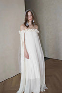 Vogsion Off-Shoulder Pleated Maxi Dress Cream Rose Appliqué 2026 – romantic boho flowy summer vacation dress with cape sleeves and veil headpiece, elegant cottagecore style worn in minimalist studio