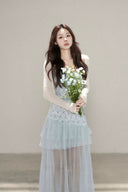 Vogsion customer wearing the Céleste light blue floral tiered tulle maxi dress with sheer skirt and romantic aesthetic for high-end summer fashion.