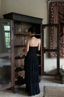 Back view of the Vogsion Nocturne black halter lace maxi dress showcasing the elegant open-back silhouette, layered ruffle skirt and flattering fit designed for both petite and taller women.