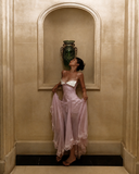 Blush pink petite wedding guest ruffle dress with ruched bodice and white lace bust detail indoor