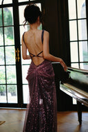 Woman in a Vogsion "Midnight Butterfly" Iridescent Sequin Backless Evening Gown standing by a piano indoors