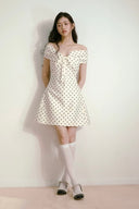 Retro-inspired polka dot A-line mini dress with elegant off-shoulder neckline, feminine and romantic aesthetic