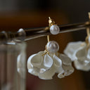 Floral earrings with pearl accents on a blurred background