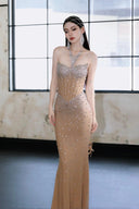 Woman in a Vogsion Sparkly Crystal Rhinestone Nude Mermaid Halter Prom Dress standing in front of a large window.