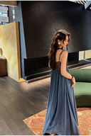 Woman in a blue dress standing in a modern interior setting