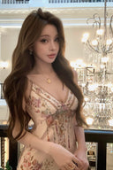 Woman in a Vogsion Adorned in Aranjuez Bias Cut Slipdress standing in an elegant interior setting with chandeliers.