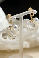 Vogsion Sculptural Petal & Lustrous Drop Earrings on a white stand with a soft white background