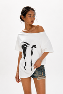 Petite off shoulder white graphic t-shirt for women featuring an oversized loose fit, abstract eye print and breathable cotton fabric. A versatile summer top that can be worn off the shoulder or as a boat neck, flattering for petite frames, short torsos and everyday streetwear outfits.