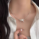 Vogsion Céleste Pearl Lariat Necklace with a silver clasp worn by a person