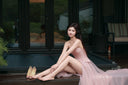 Vogsion blush pink corset tulle gown sitting pose elegant outdoor scene