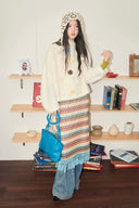Cozy mohair flower sweater paired with striped knit skirt and yellow scarf — Vogsion winter collection look.