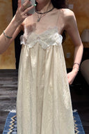 Vogsion Santorini Scalloped Lace Maxi Dress in cream, featuring delicate floral lace bust detailing and a fluid, floor-length silhouette.