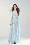 Woman wearing a light blue floral dress against a white background