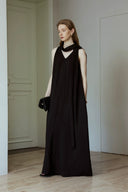 Woman wearing a black sleeveless dress in an indoor setting