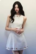 Real customer wearing Vogsion Floral Embroidered Linen Mini Dress in off-white, sleeveless with delicate floral embroidery on neckline and he