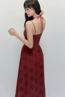 Back view of crimson embroidered maxi dress with adjustable strappy halter tie, elegant sleeveless autumn dress for fall occasions and romantic evening style.