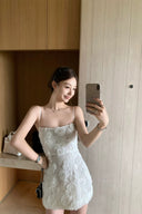 Vogsion 3D Floral Rose Embroidered White Mini Dress on real customer in modern home setting, spaghetti strap little white dress for bridal shower rehearsal dinner party, floral embroidered mini dress with black chain bag