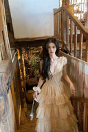 Close-up of a woman in a Vogsion romantic ruffled V-neck dress standing on a rustic wooden staircase.