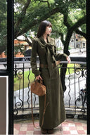 Vintage inspired moss green corduroy maxi dress styled with bow tie neckline and matching waist belt, chic fall outfit for autumn strolls, winter dinner parties, and sophisticated long sleeve fashion looks.