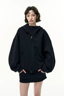 Person wearing a black hoodie with a brand logo on a white background