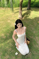 A woman modeling the Vogsion Seraphina white floral lace maxi dress with delicate ruffle straps and a form-fitting mermaid silhouette, perfect for a romantic vacation aesthetic.