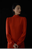 Woman wearing a red dress against a black background