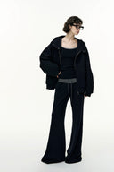 Person wearing a black outfit with a jacket and pants on a white background
