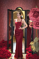 Woman in Vogsion Amara Wine Red Square Neck Maxi Dress standing in front of a mirror with red roses around.