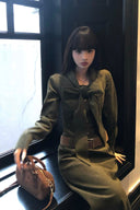 Elegant autumn corduroy long sleeve maxi dress in moss green with oversized bow tie and belted waist, perfect fall and winter outfit for dinner party, holiday gatherings, and cozy city chic wear.