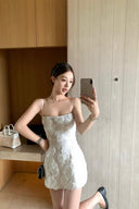 Vogsion 3D Floral Rose Embroidered White Mini Dress on real customer in modern home setting, spaghetti strap little white dress for bridal shower rehearsal dinner party, floral embroidered mini dress with black chain bag