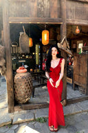Vogsion real customer (not a professional model) wearing the Poppy Red Ruffle Maxi Dress in a rustic scenic setting — body-hugging red maxi dress with ruffle straps and plunging V-neckline