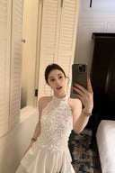 Vogsion Luna Blossom Tiered Ruffle Halter Dress in white with 3D floral appliqué and cascading ruffle tiers – worn by real everyday customer on elegant staircase, authentic fit and styling, 2026 wedding guest dress trend