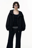 Person wearing a black jacket and pants on a white background