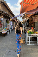 Back view of model wearing long blue floral slip dress with red flower prints, casual yet elegant vacation maxi dress, perfect for summer market strolls and holiday getaways.