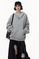 Person wearing a gray hoodie and black skirt with a white background