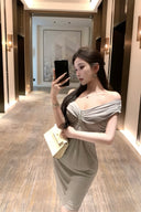 Vogsion Seraphina off-shoulder ruched gray midi dress with crystal detail in a luxury hotel hallway.