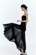 Woman wearing a black dress with a flowing skirt on a white background
