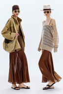 Two women wearing coordinated outfits with beige and brown tones on a white background.
