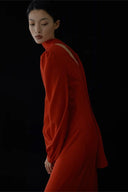 Person wearing a red dress with a white stripe on a black background