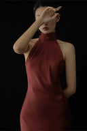 Woman wearing a burgundy dress against a black background