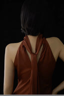 Brown halter top worn by a person against a black background