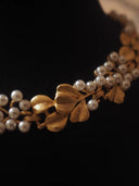 Close-up of a gold headband with pearls on a dark background