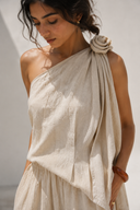 Close-up of the VOGSION Élan Quiet Luxury Linen Set showcasing premium textured linen fabric, sculptural floral shoulder detail, elegant one-shoulder draping, and refined craftsmanship inspired by quiet luxury fashion.