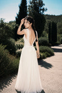 Vogsion Amber Light Lace Spliced Open Back Tie Strap Maxi Dress styled with braided hairstyle and clutch bag, featuring floral lace open back, flowing ivory chiffon skirt, romantic bridal shower outfit, summer wedding guest dress, elegant vacation evening maxi dress.