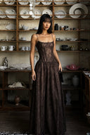 Woman in Vogsion Mara Maxi Dress standing in a room with shelves displaying various items.